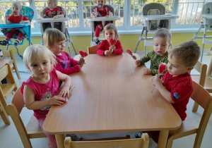 Zdjęcie dzieci przy stole z upominkami, które dostały z okazji Walentynek.